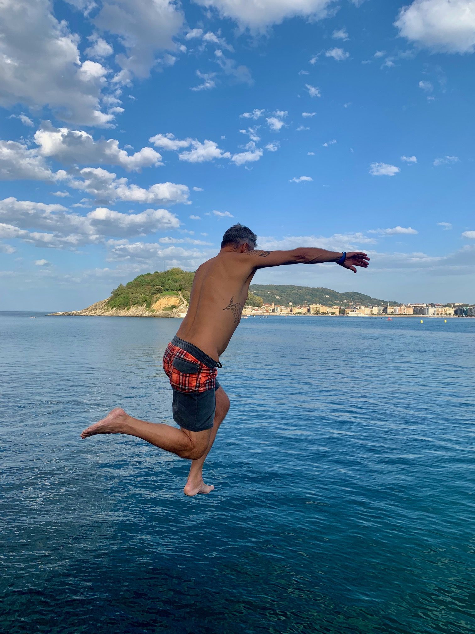 jumping into the sea in La Concha bay San Sebastian.
